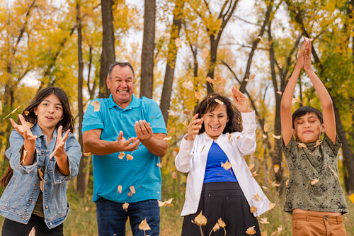 Indigenous family playing in the fallen leaves