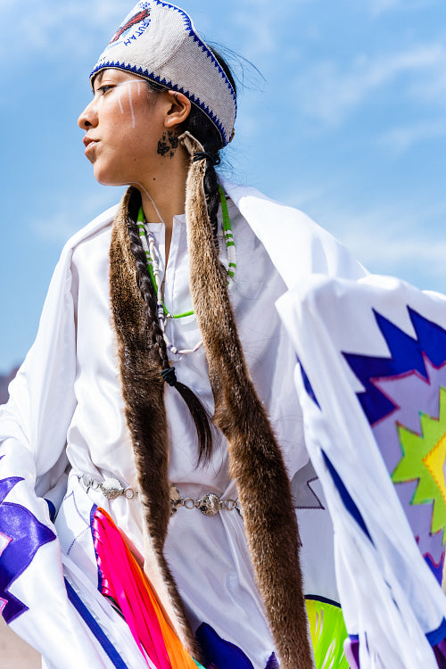 A young Native woman in traditional clothing and regalia