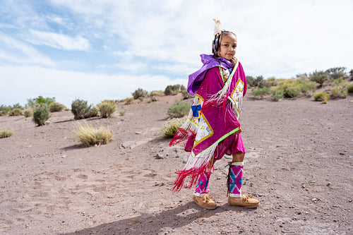 Young Native girl wearing traditional regalia outside