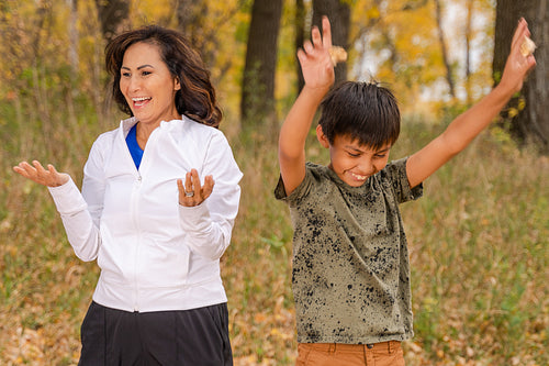 Indigenous family playing in the fallen leaves