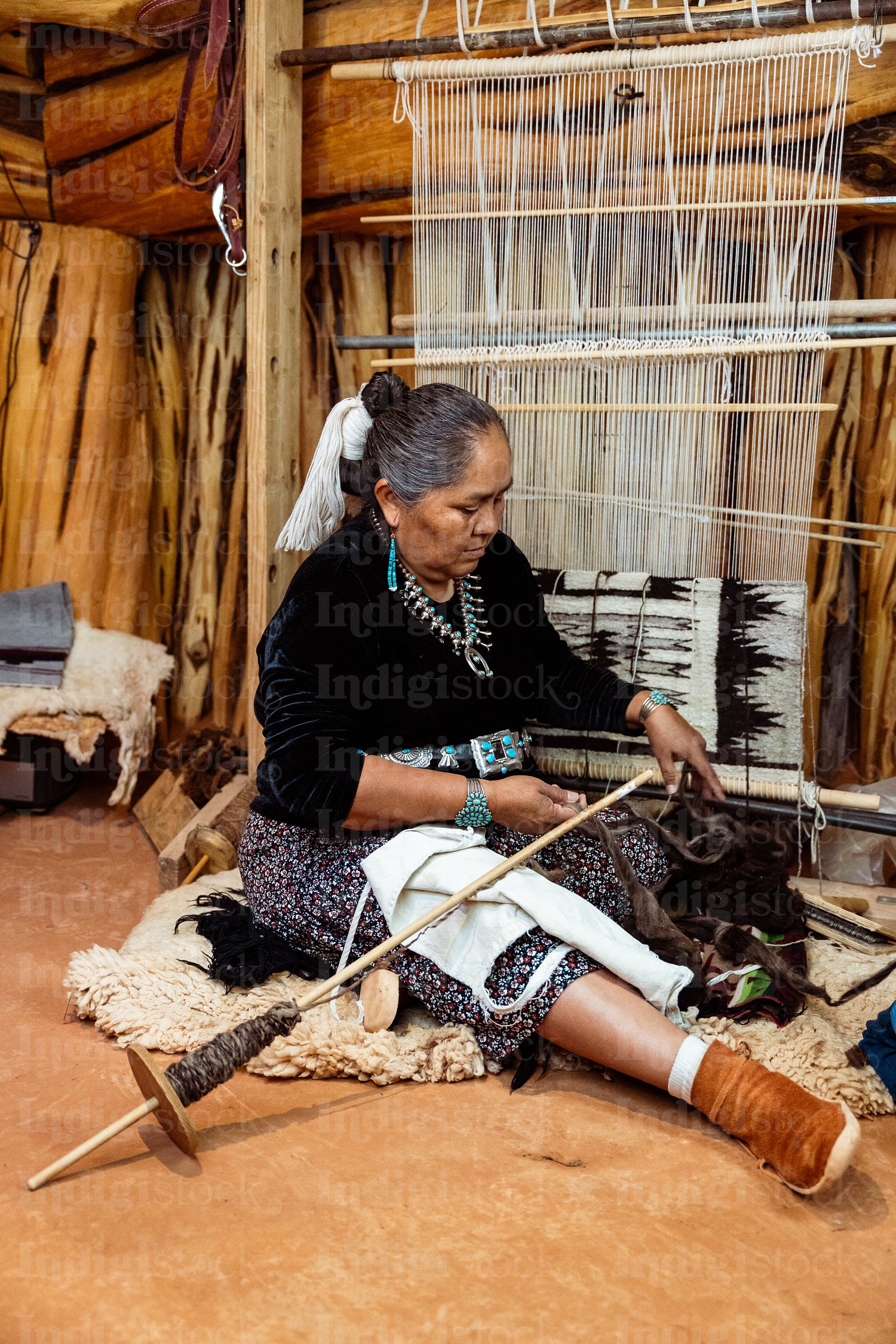 Indigenous woman weaving a traditional pattern in Hogan Earthlod