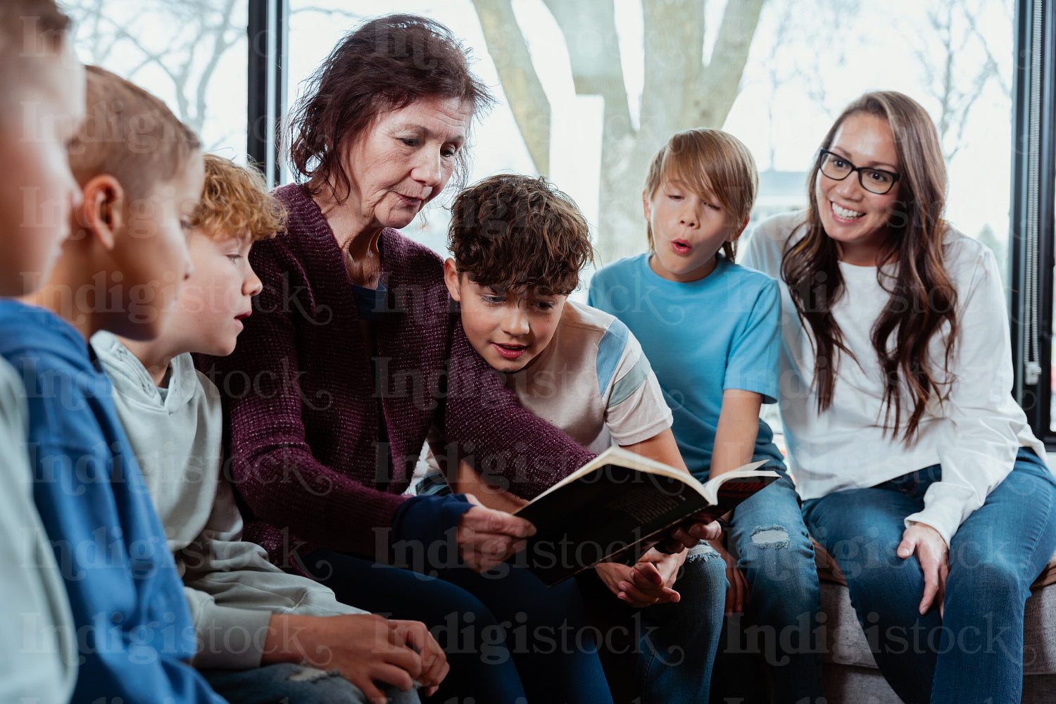 A family of Native Peoples reading a book together