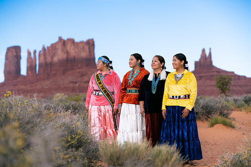 An indigenous family wearing traditional regalia outside