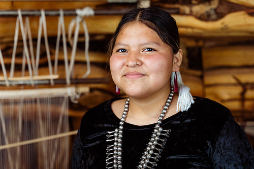 A Native American Navajo woman standing inside a Hogan Earthlodg