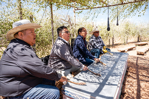 Native men singing songs and playing instruments