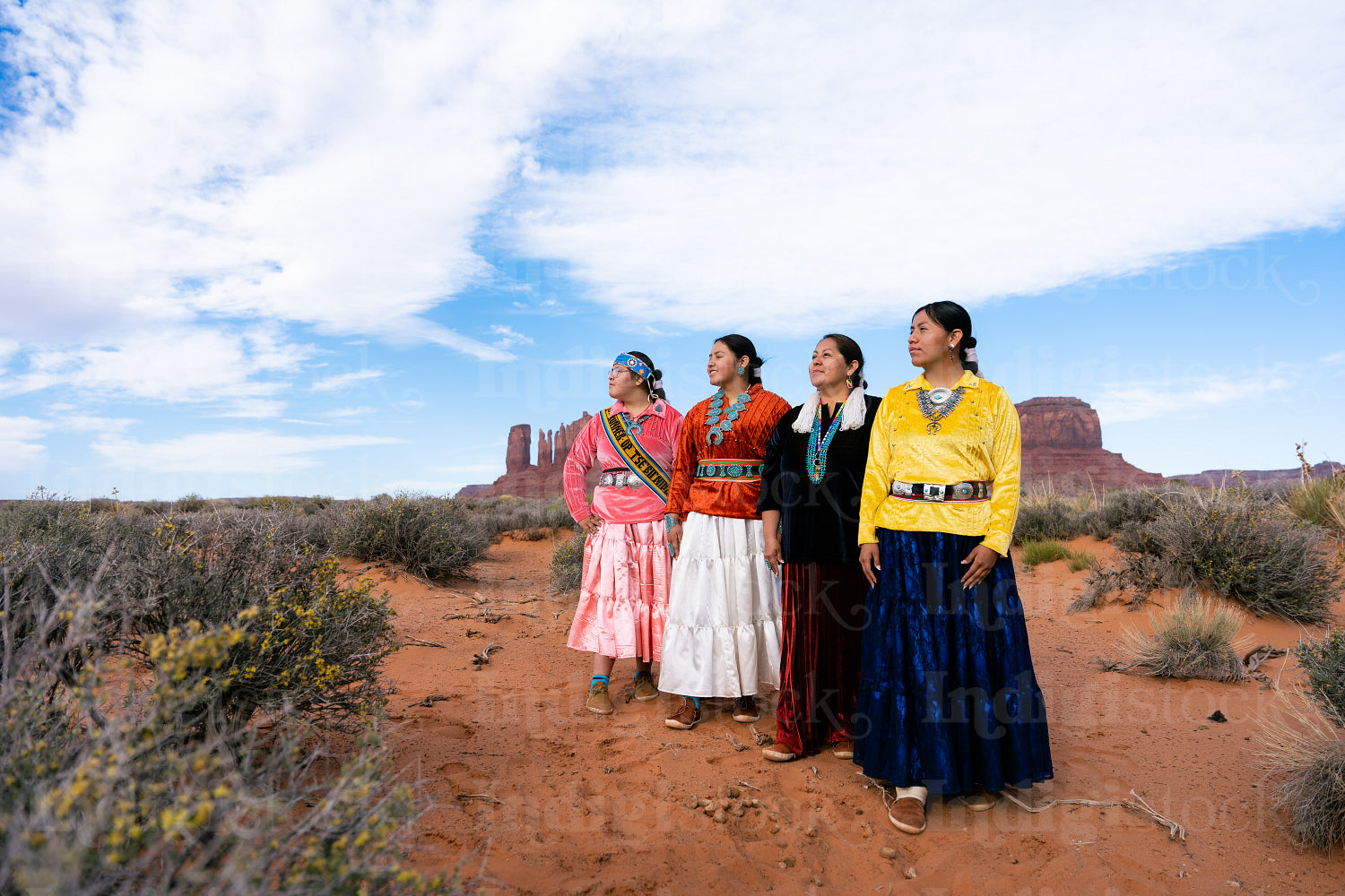 An indigenous family wearing traditional regalia outside