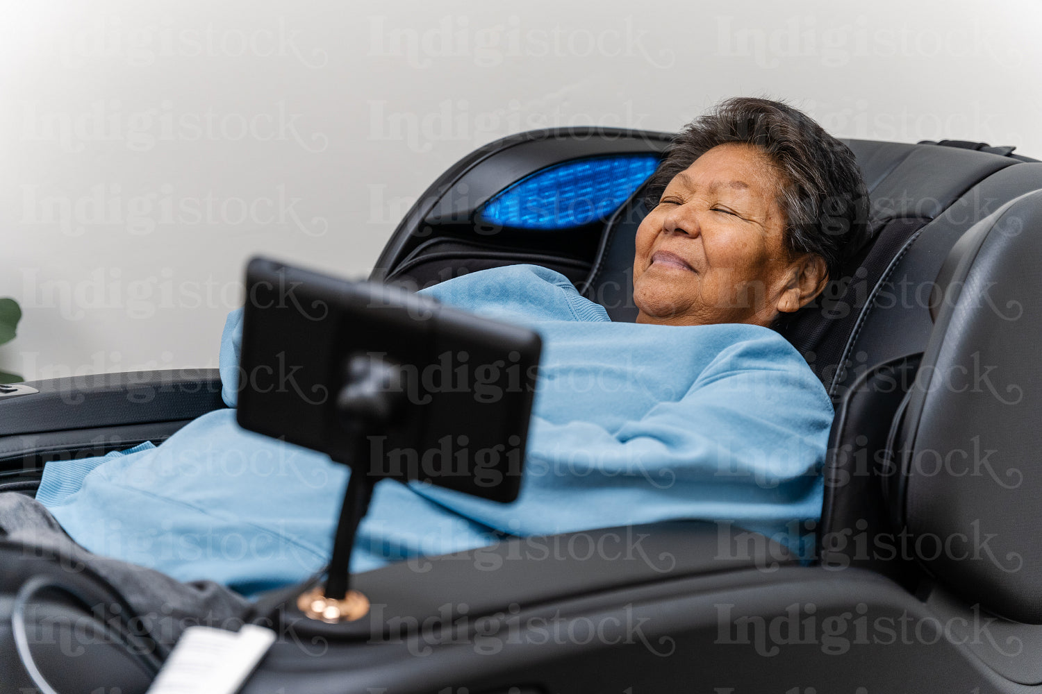 Native Elder relaxing in message chair at health center