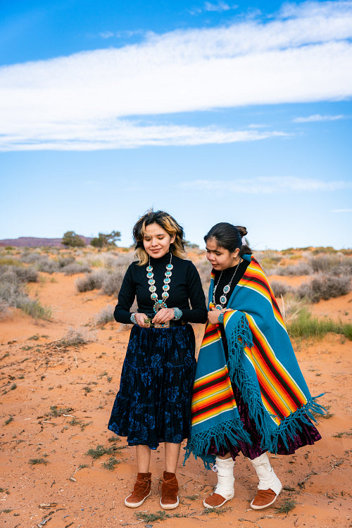 Young native youth wearing traditional regalia outside