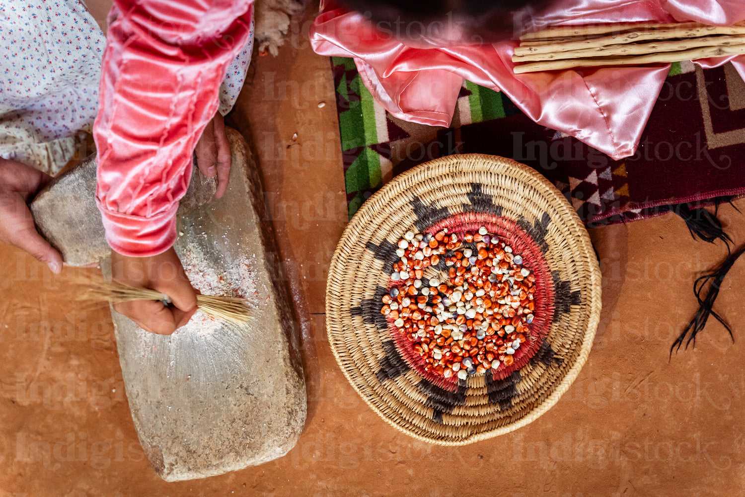 Two Navajo girls grinding corn into flour in Hogan Earthlodge 