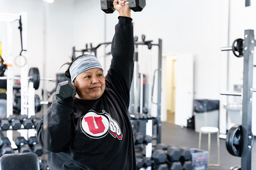 A Indigenous woman working out in a gym