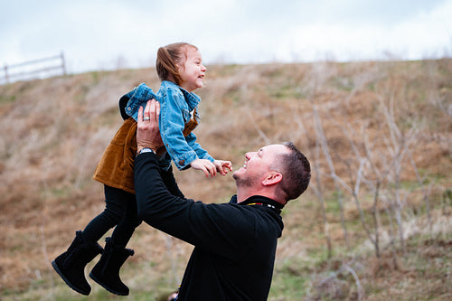 A father pushing his daughter on a swing