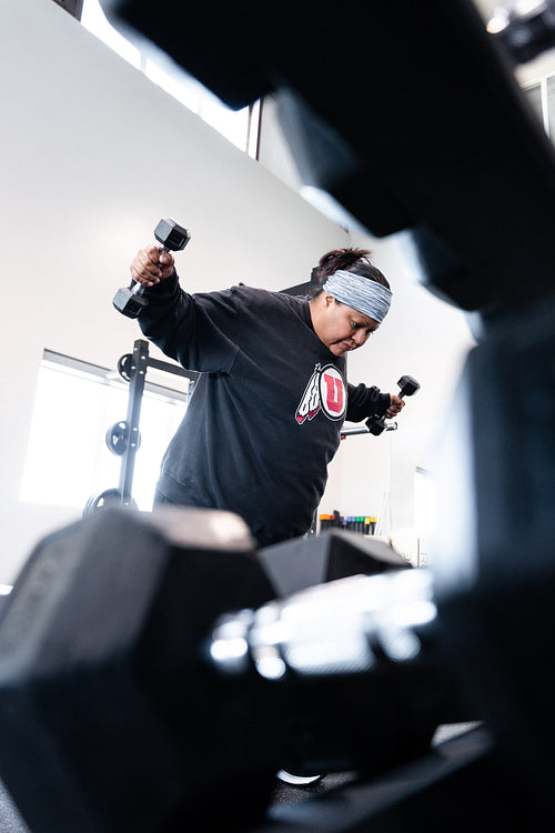 A Indigenous woman working out in a gym