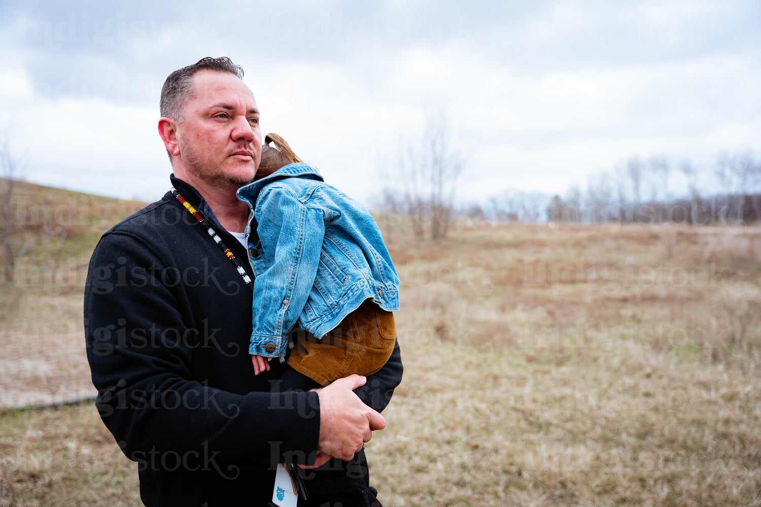 A father pushing his daugher on a swing