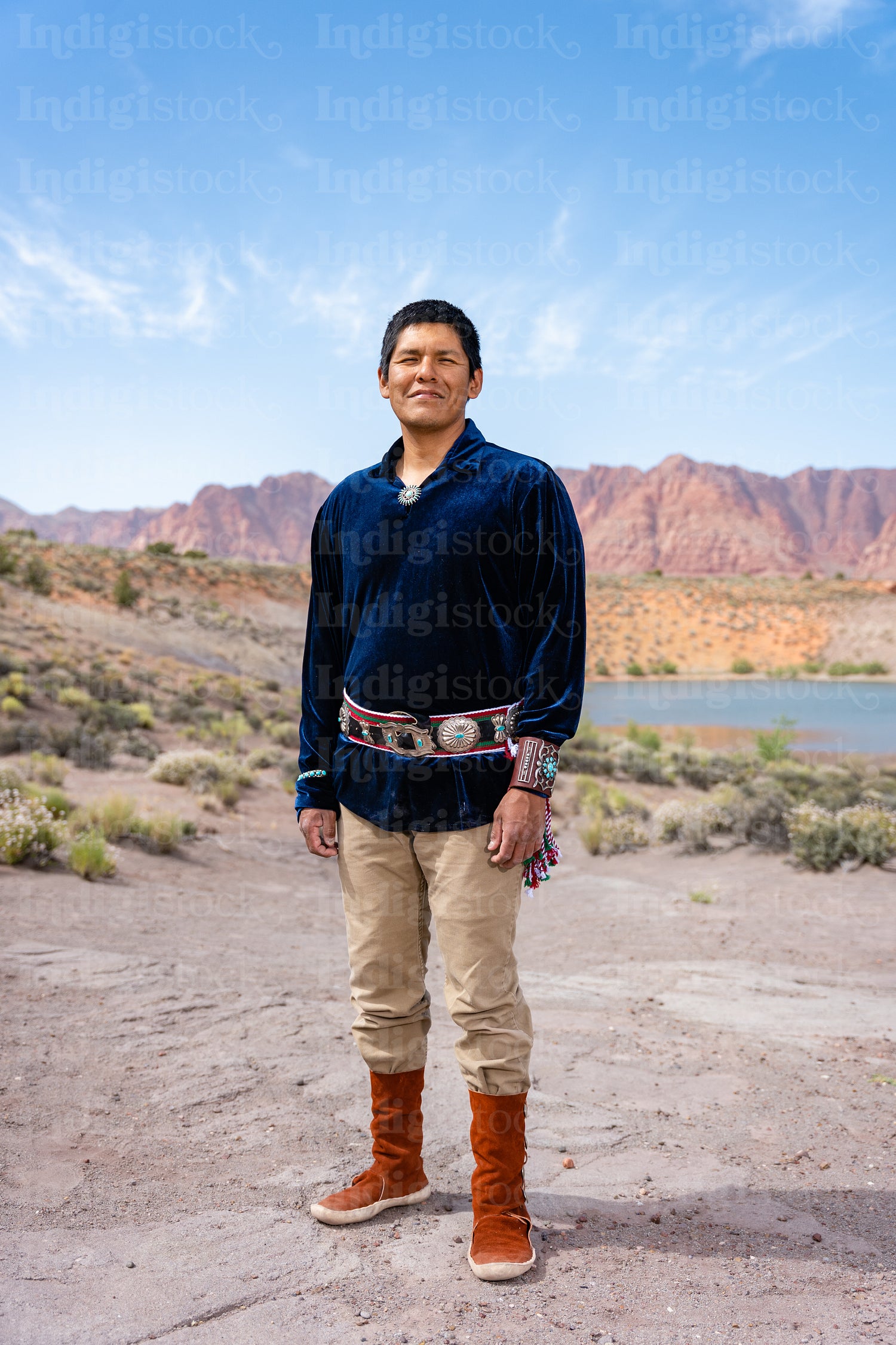 An Indigenous Man wearing traditional regalia clothing outside