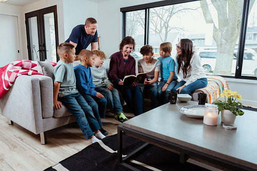 A family of Native Peoples reading a book together