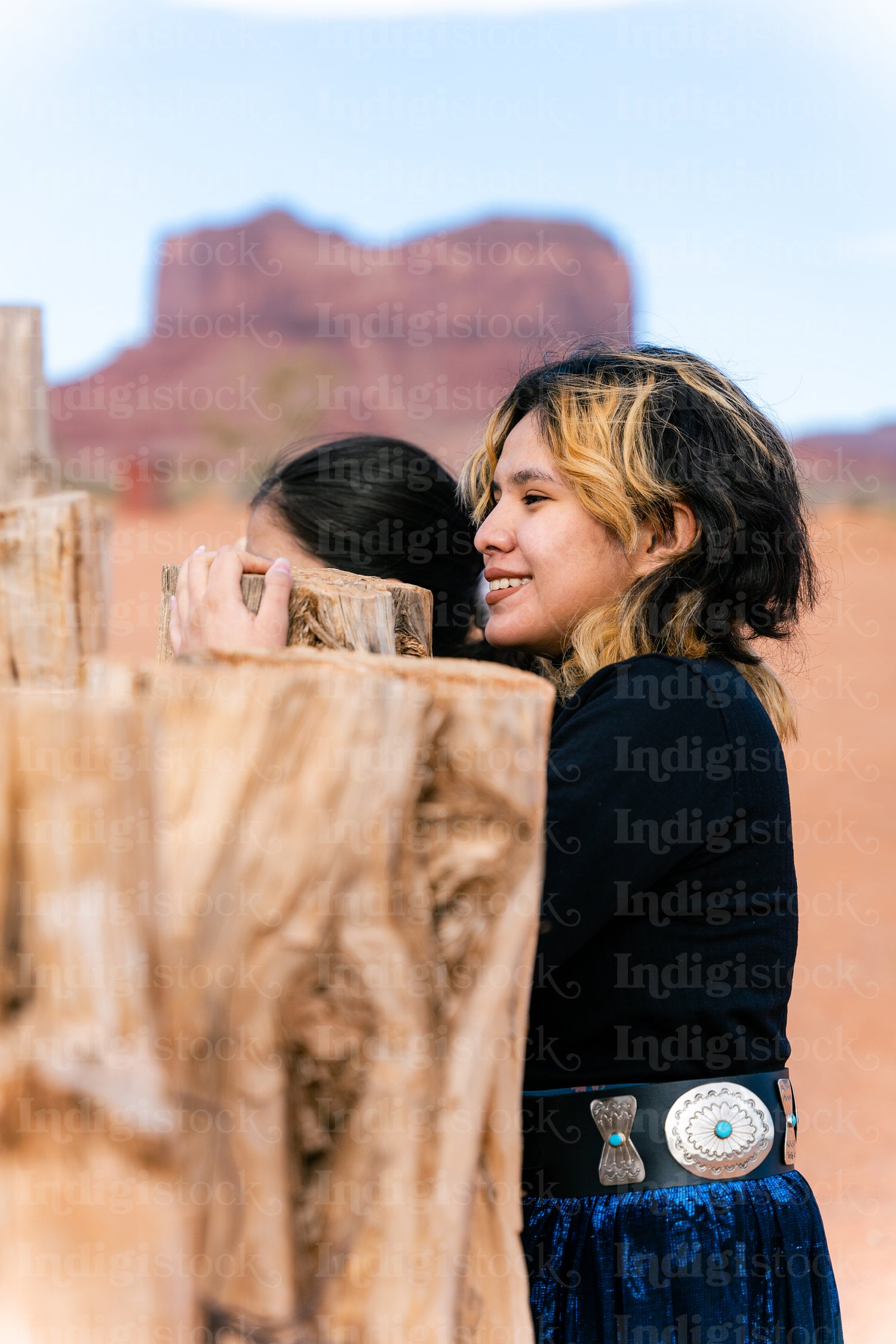 Young native youth wearing traditional regalia outside 