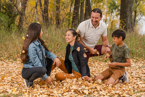 Indigenous family playing in the fallen leaves