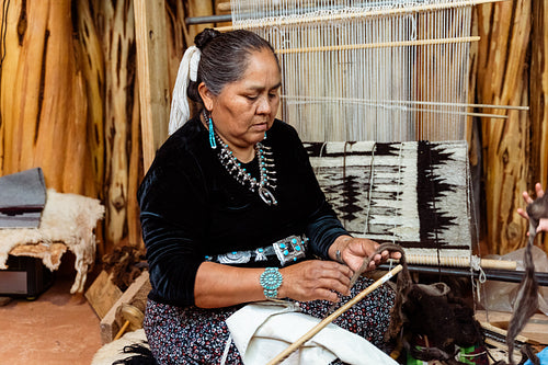 Indigenous woman weaving a traditional pattern in Hogan Earthlod