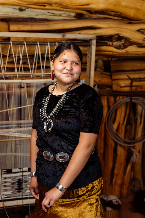 A Native American Navajo woman standing inside a Hogan Earthlodg