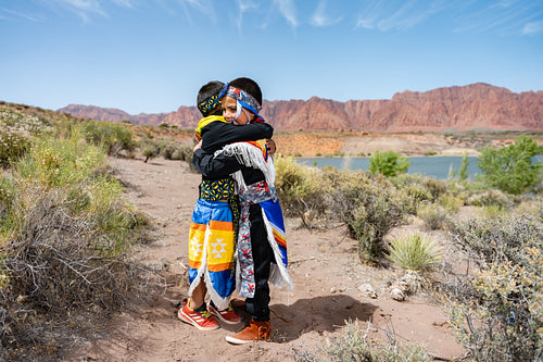 Two young Native American boys wearing traditional regalia outsi