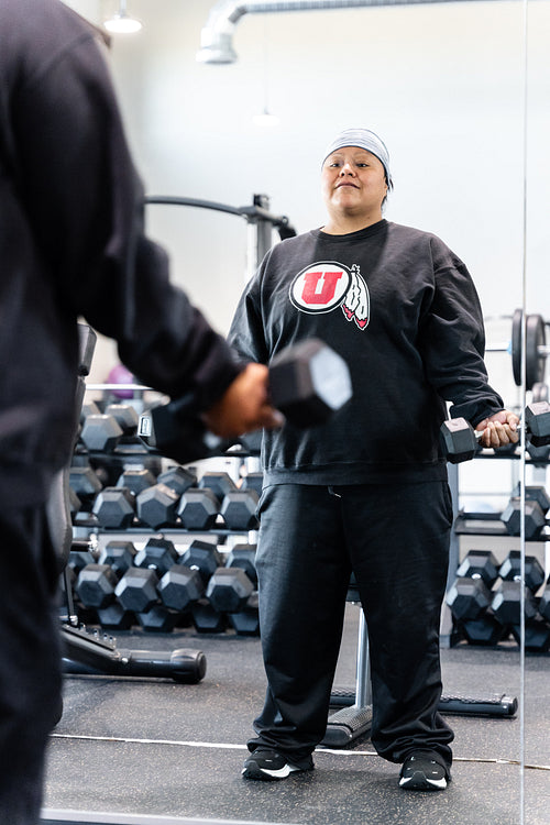 A Indigenous woman working out in a gym