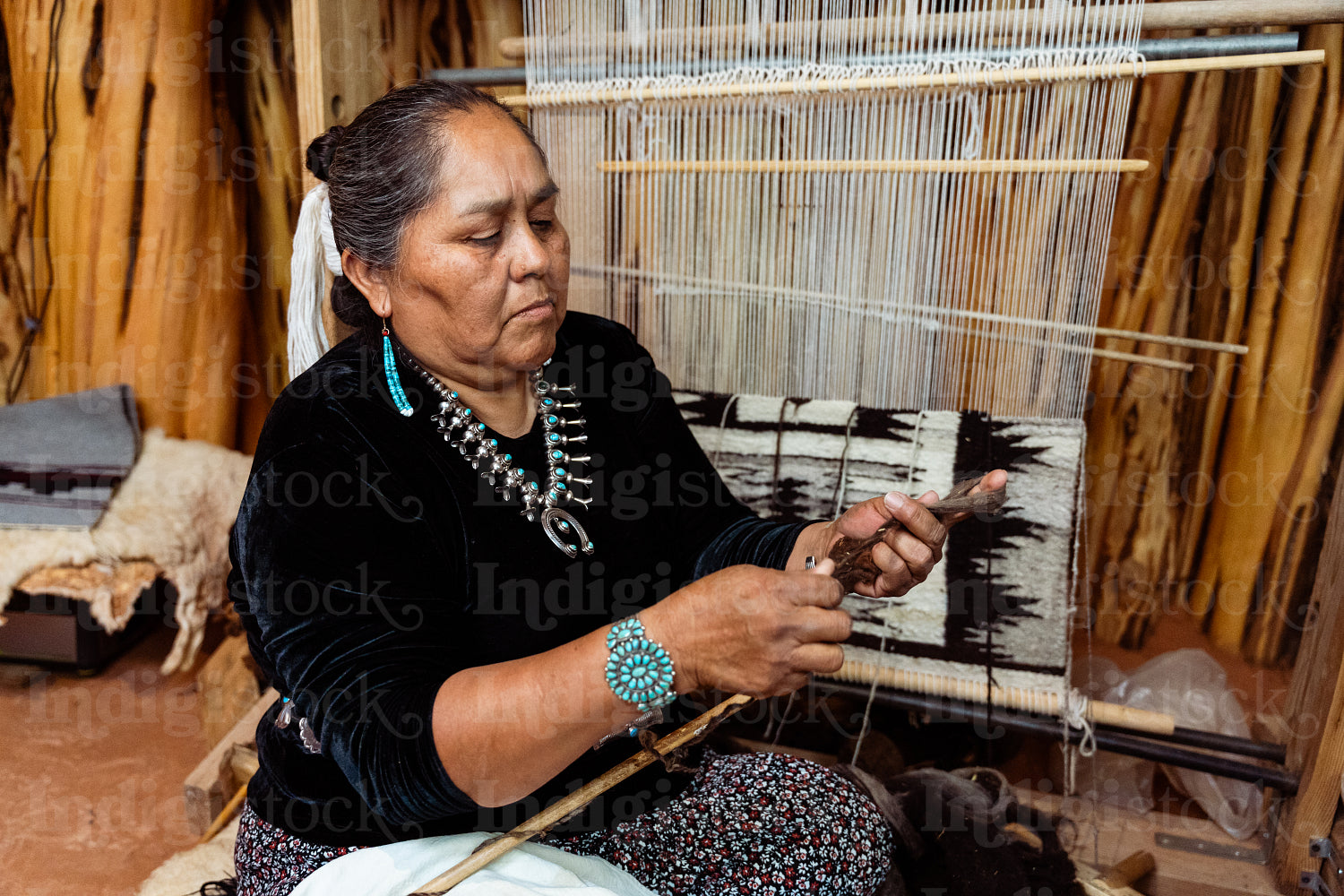 Indigenous woman weaving a traditional pattern in Hogan Earthlod