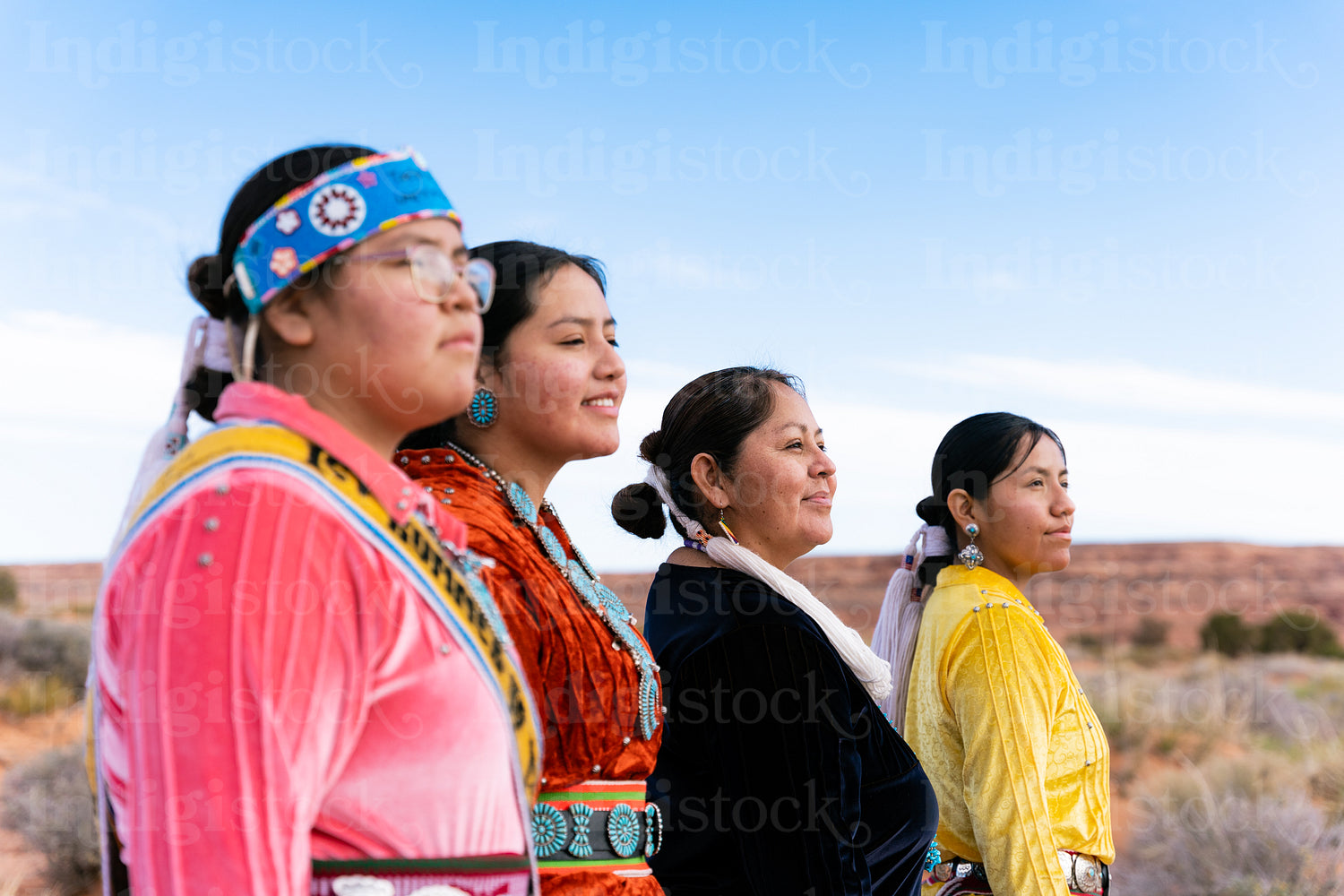 An indigenous family wearing traditional regalia outside