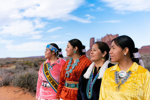 An indigenous family wearing traditional regalia outside