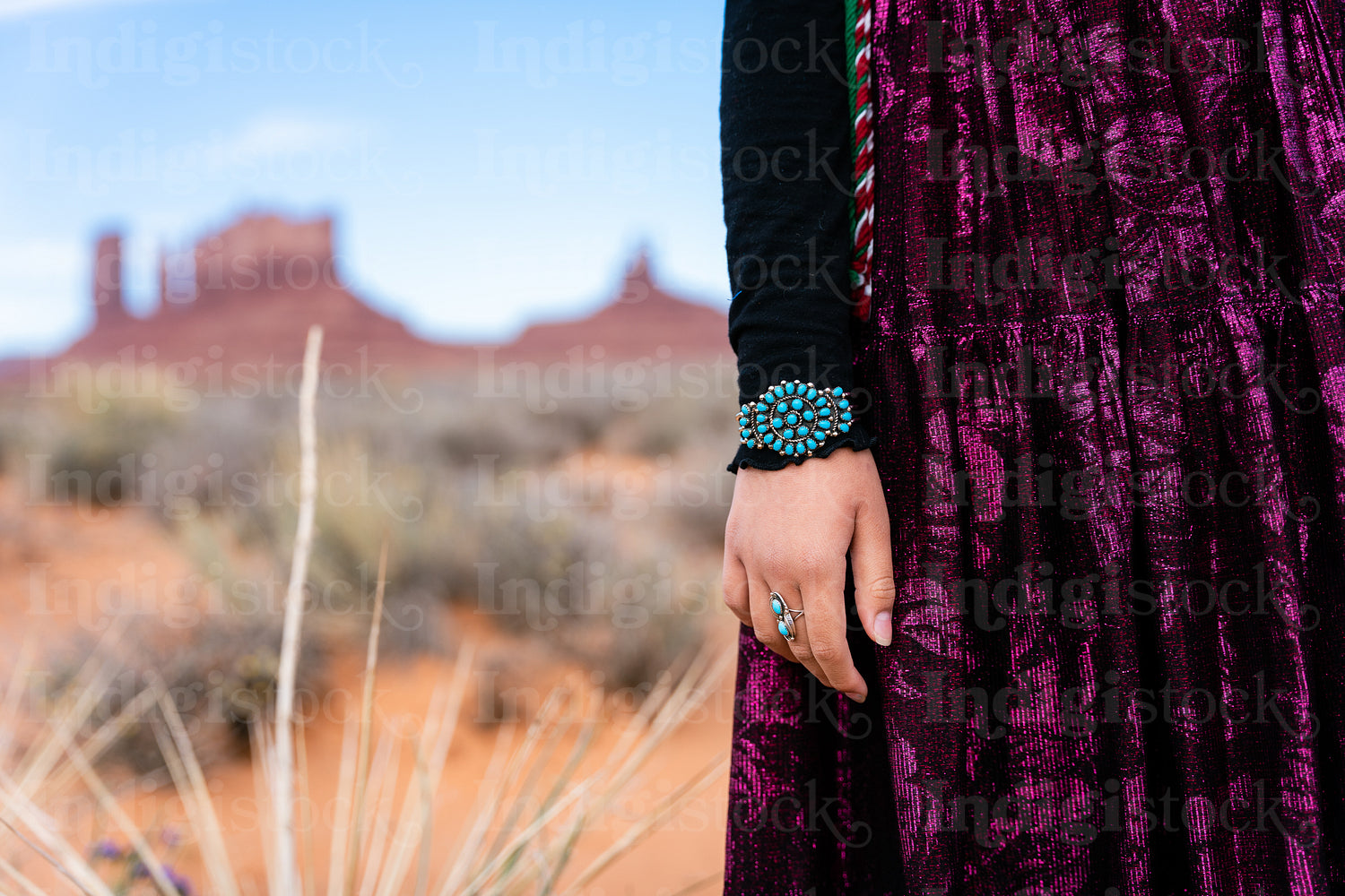 A young native teenager wearing traditional regalia outside