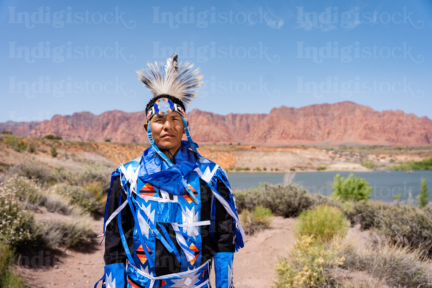 A Native Man wearing traditional regalia outside