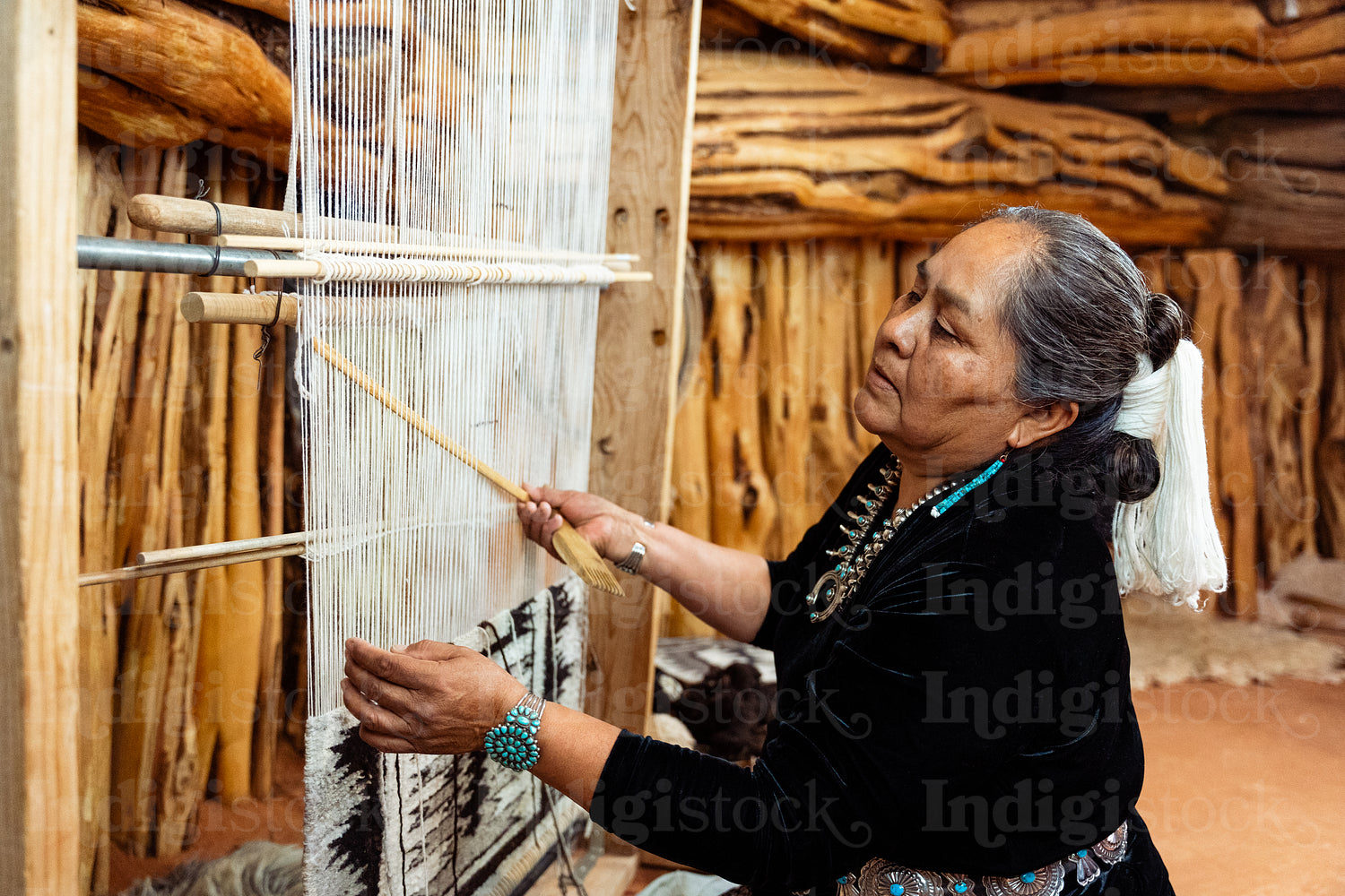 Indigenous woman weaving a traditional pattern in Hogan Earthlod