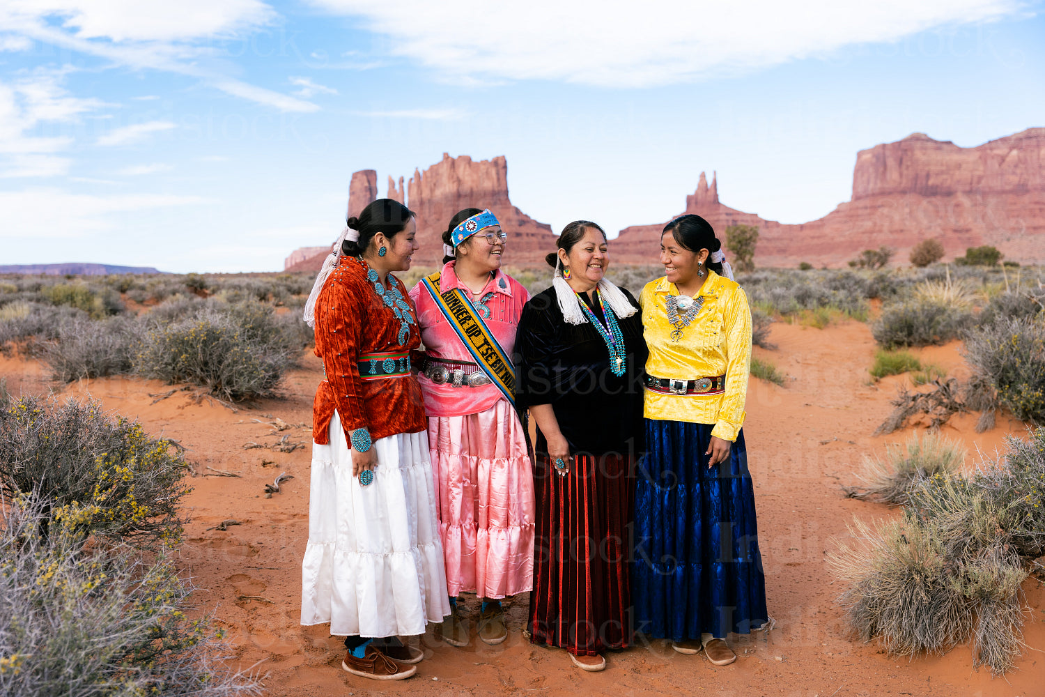 An indigenous family wearing traditional regalia outside