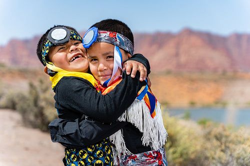 Two young Native American boys wearing traditional regalia outsi