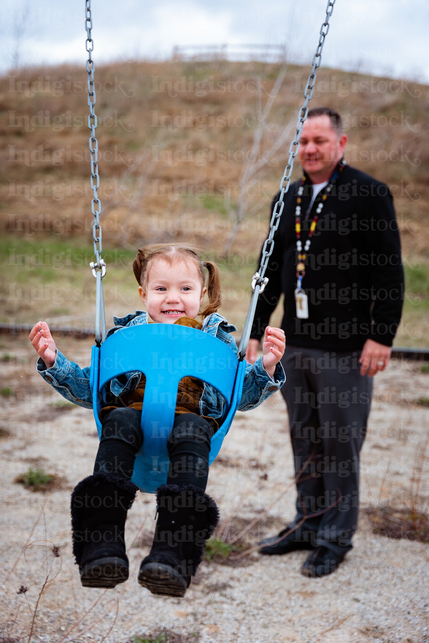 A father pushing his daughter on a swing