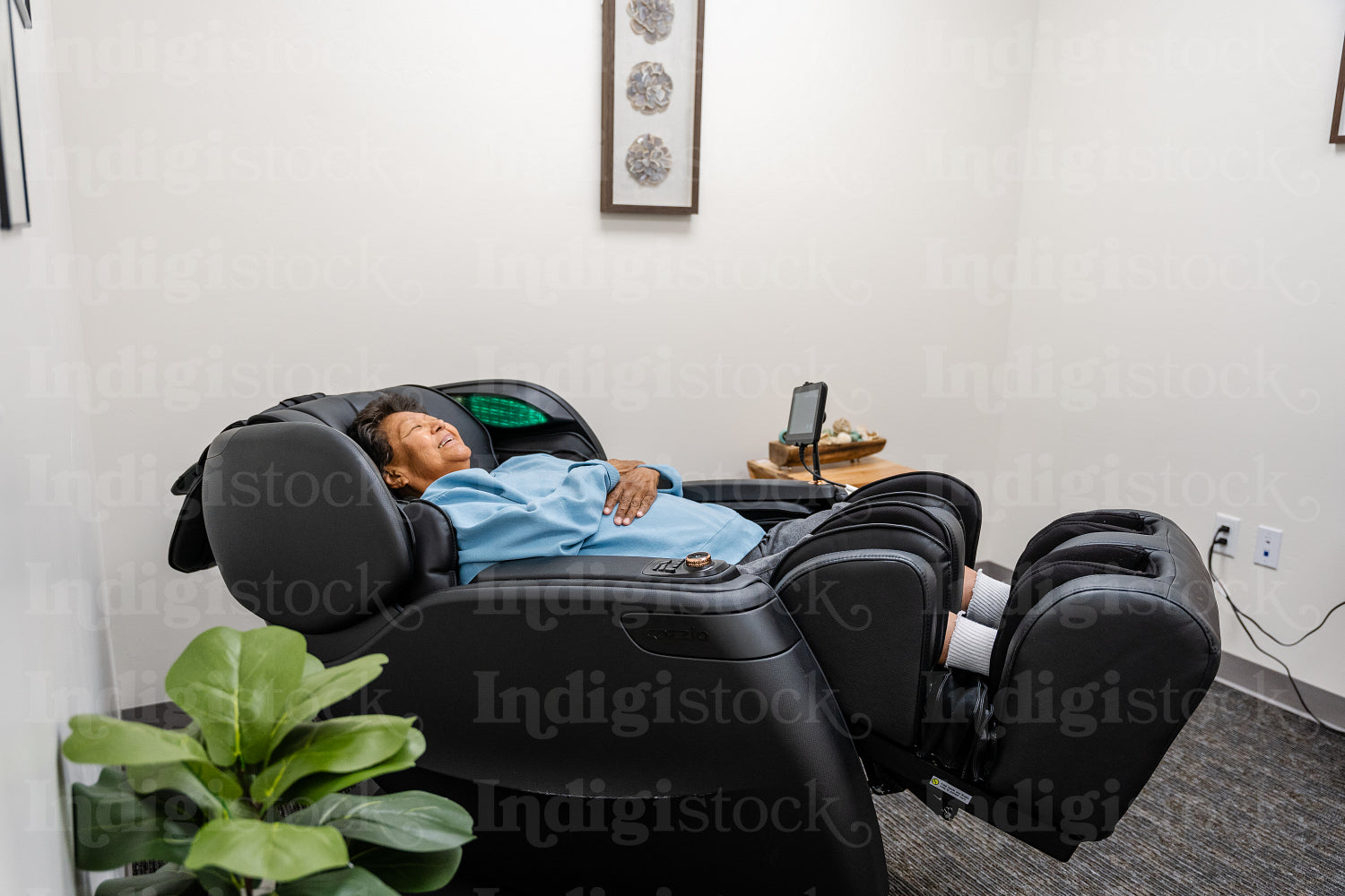 Native Elder relaxing in message chair at health center