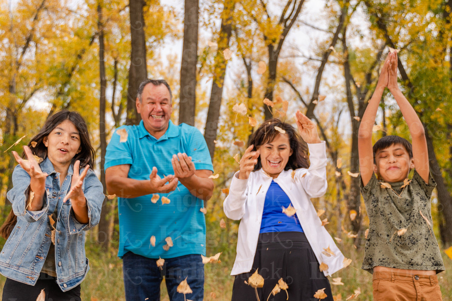 Indigenous family playing in the fallen leaves