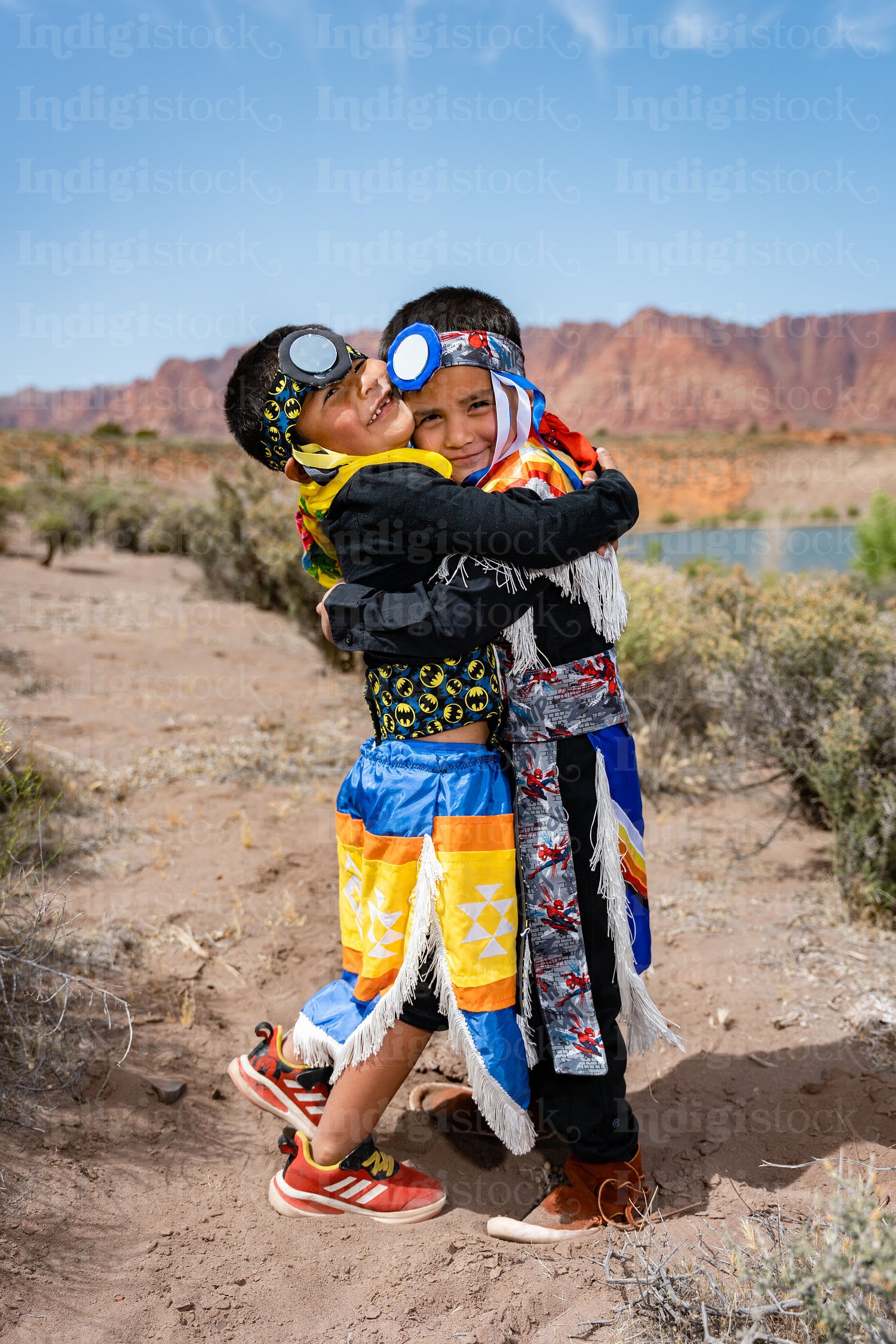 Two young Native American boys wearing traditional regalia outsi