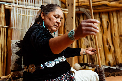 Indigenous woman weaving a traditional pattern in Hogan Earthlod