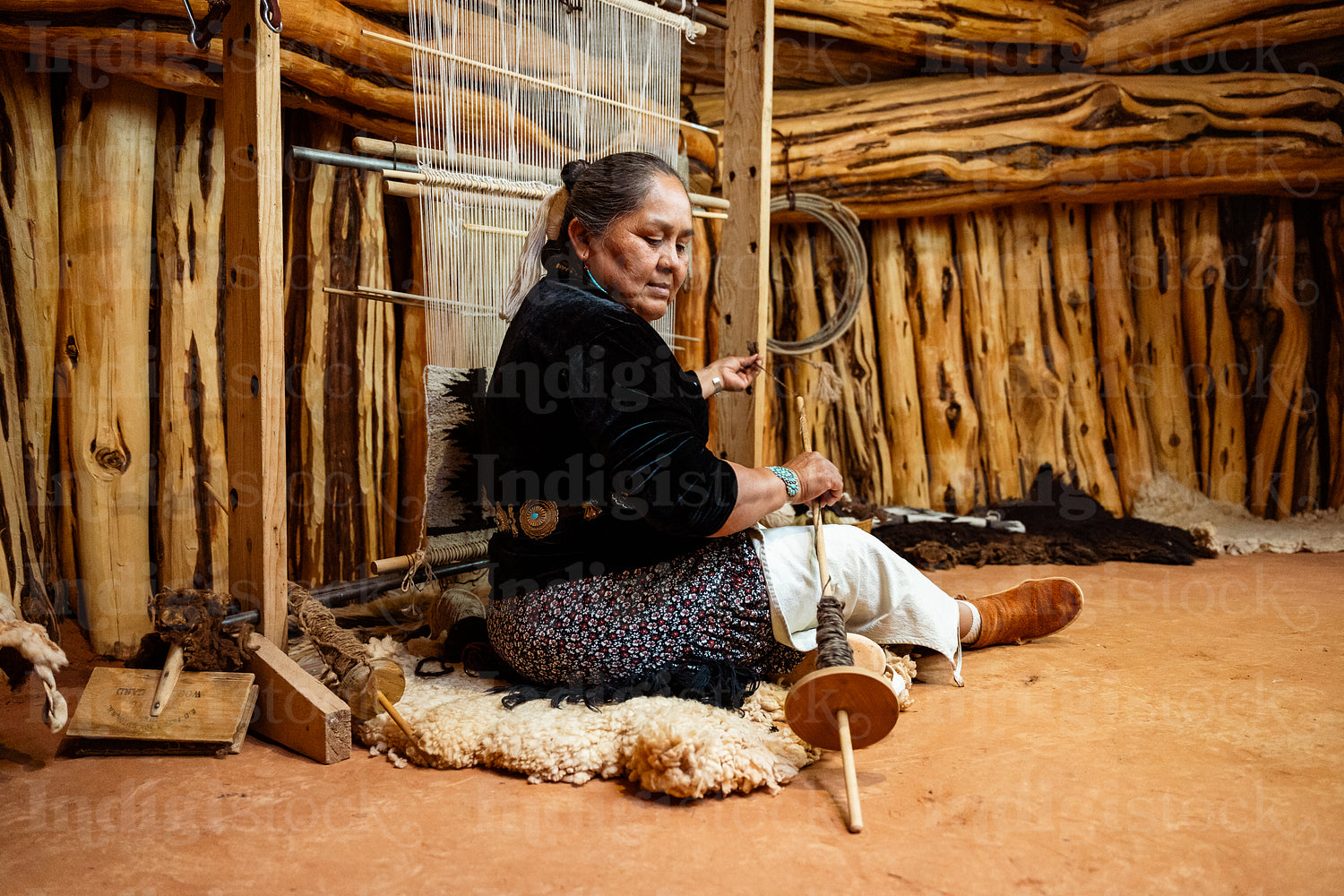 Indigenous woman weaving a traditional pattern in Hogan Earthlod