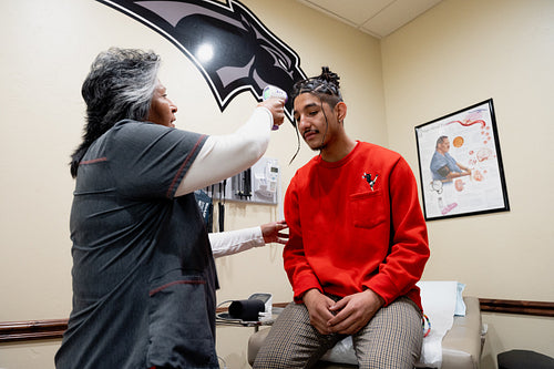 An Indigenous man being check by a native health care nurse