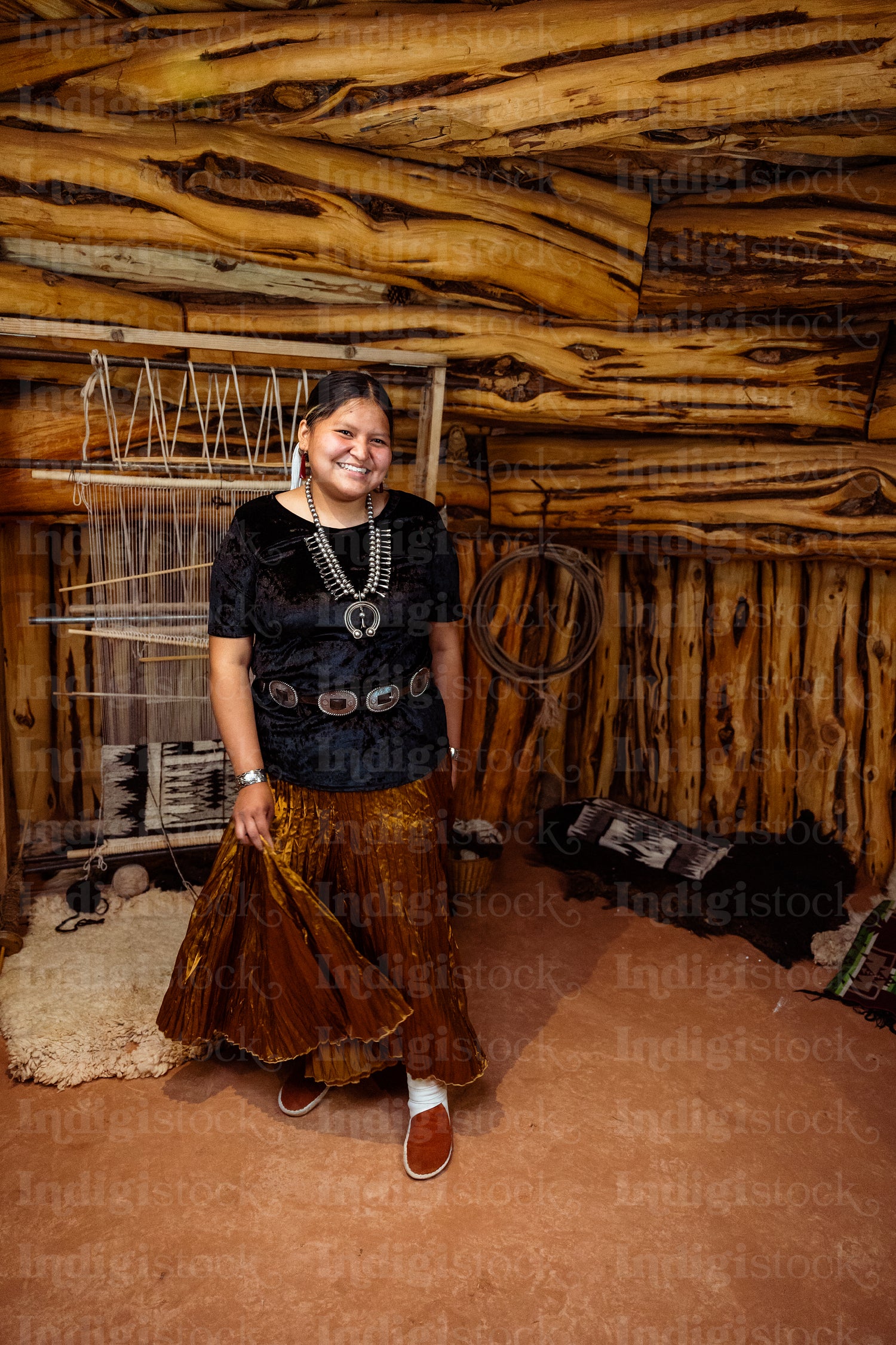 A Native American Navajo woman standing inside a Hogan Earthlodg