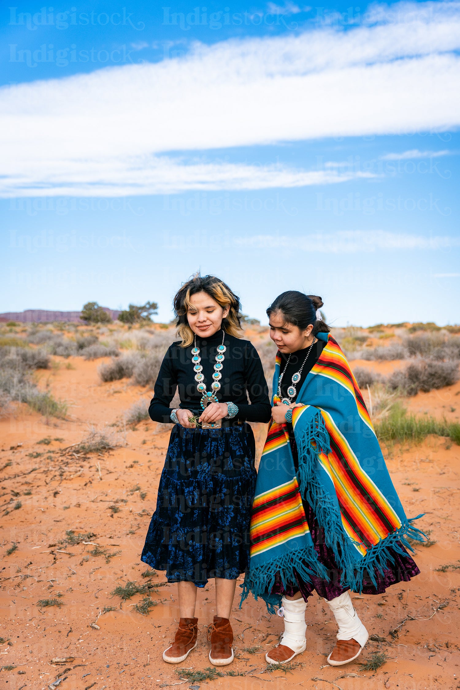 Young native youth wearing traditional regalia outside 