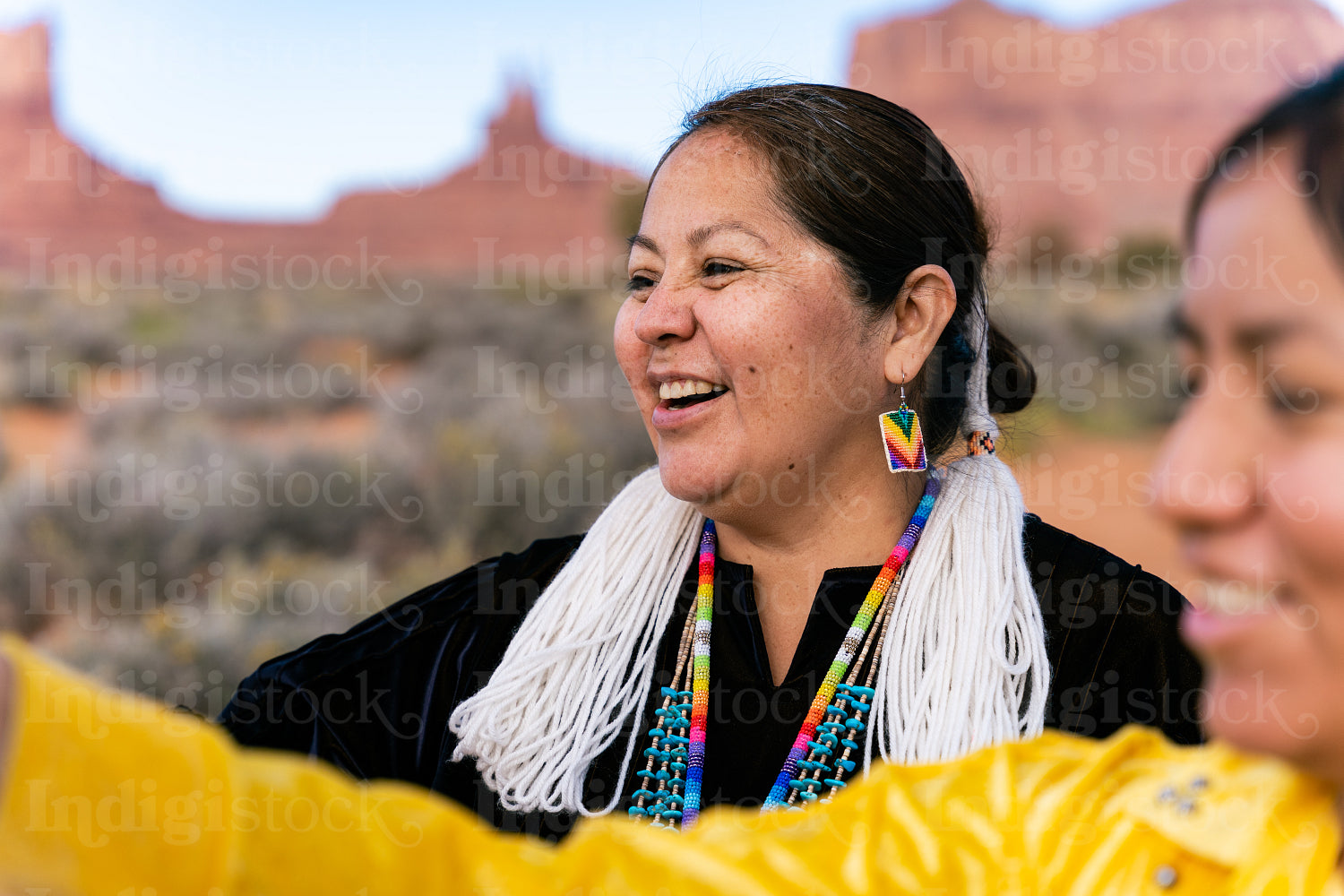 An indigenous family wearing traditional regalia outside