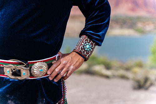 An Indigenous Man wearing traditional regalia clothing outside