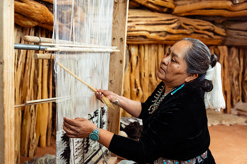 Indigenous woman weaving a traditional pattern in Hogan Earthlod