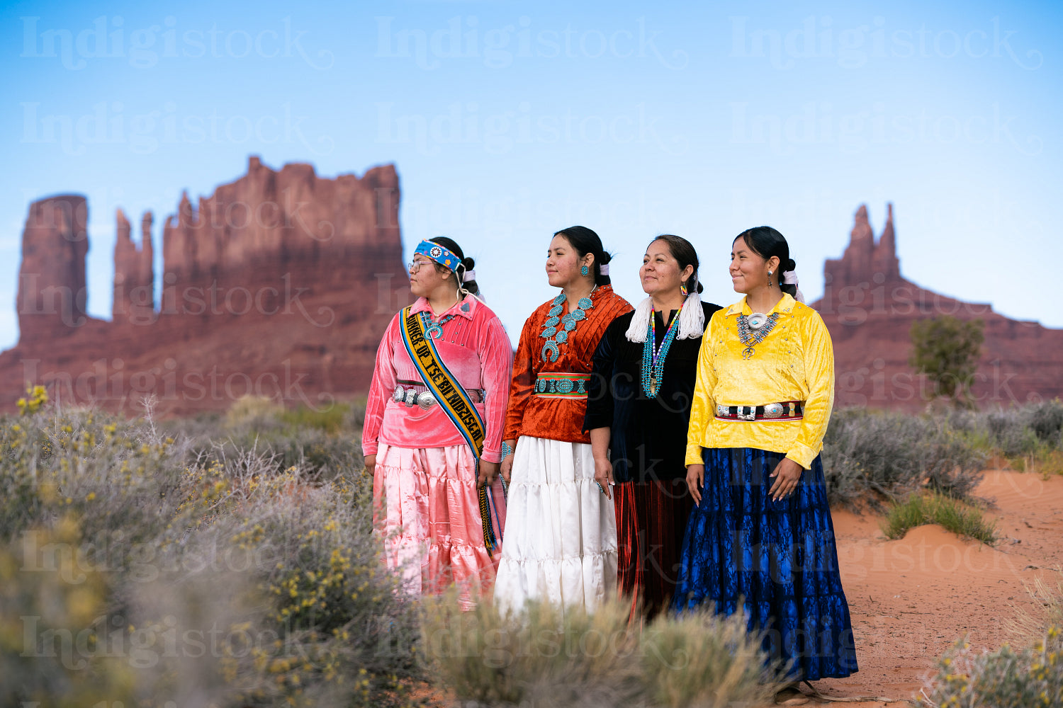 An indigenous family wearing traditional regalia outside