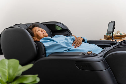 Native Elder relaxing in message chair at health center