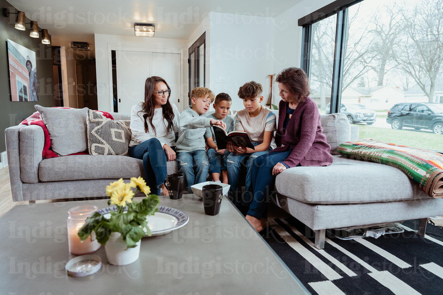 A family of Native Peoples reading a book together