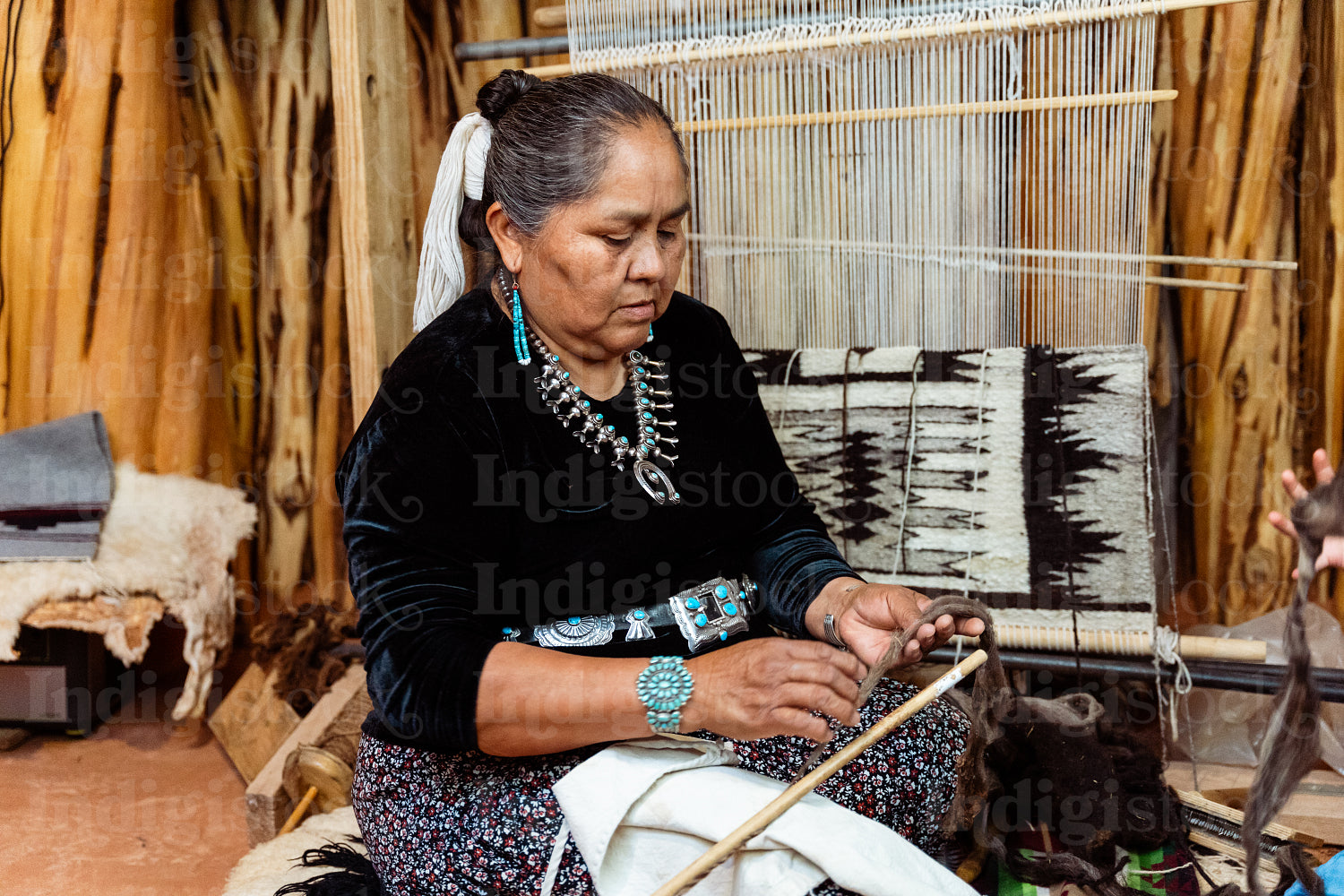 Indigenous woman weaving a traditional pattern in Hogan Earthlod