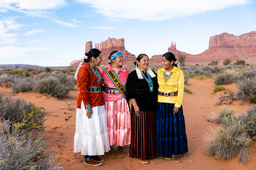 An indigenous family wearing traditional regalia outside